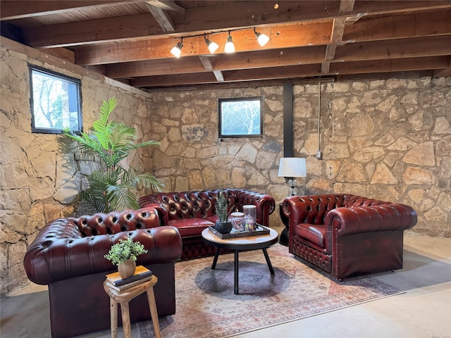 living room with beam ceiling, rail lighting, wooden ceiling, and concrete flooring