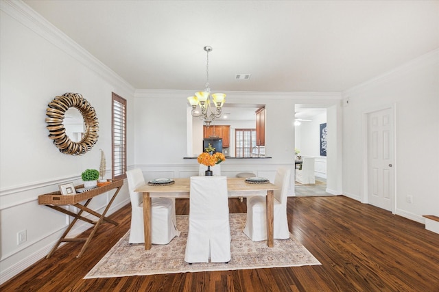 dining space featuring an inviting chandelier, dark hardwood / wood-style flooring, and crown molding