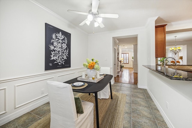 dining area featuring crown molding, ceiling fan with notable chandelier, and sink