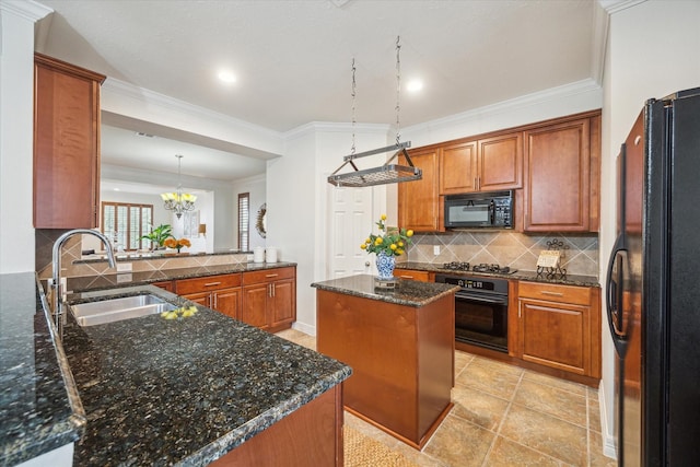 kitchen with decorative light fixtures, tasteful backsplash, a center island, black appliances, and sink