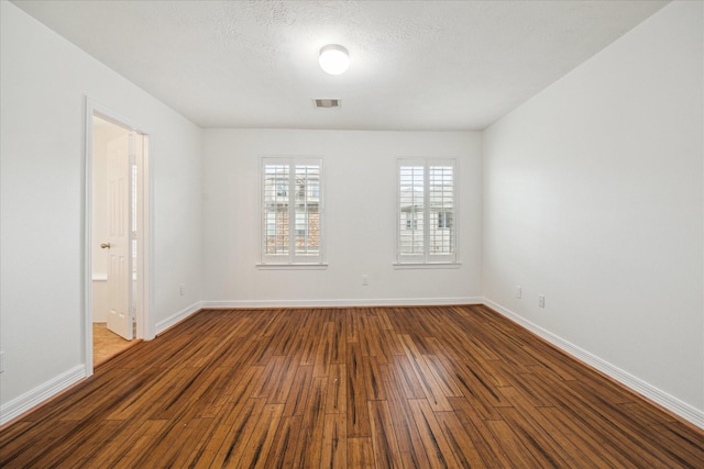 spare room with dark wood-type flooring