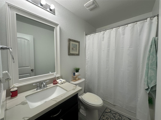 bathroom with a textured ceiling, toilet, and vanity