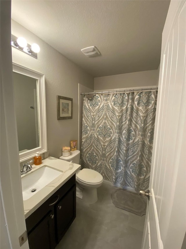 bathroom with toilet, vanity, and a textured ceiling