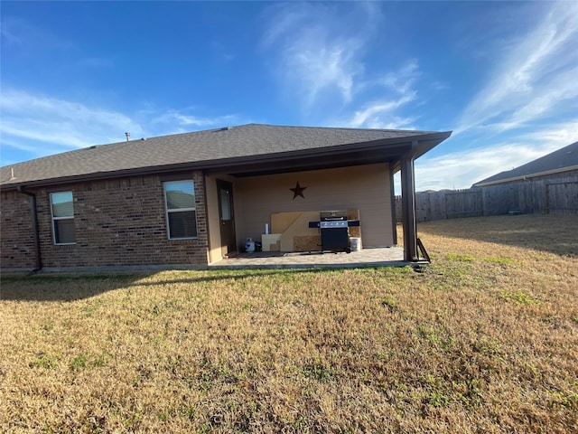 back of property with a yard and a patio