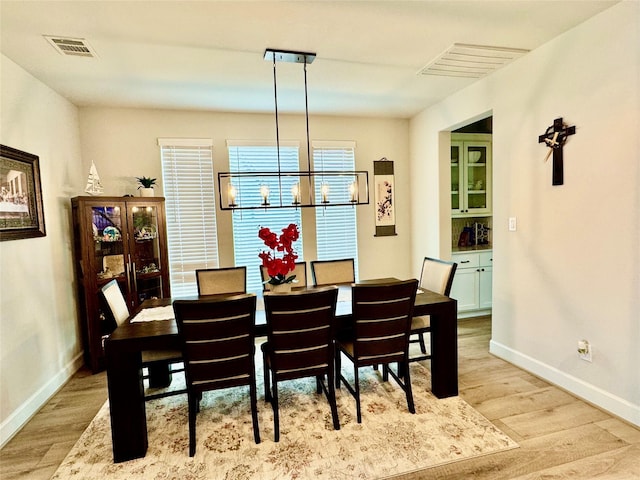 dining space featuring light hardwood / wood-style flooring and an inviting chandelier