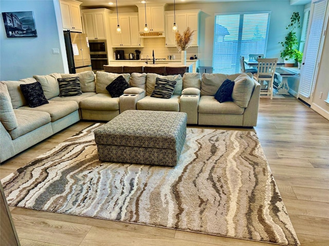 living room with light hardwood / wood-style floors and sink