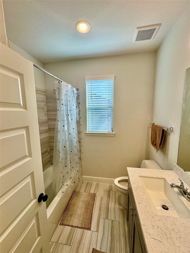 full bathroom featuring toilet, vanity, and shower / tub combo with curtain