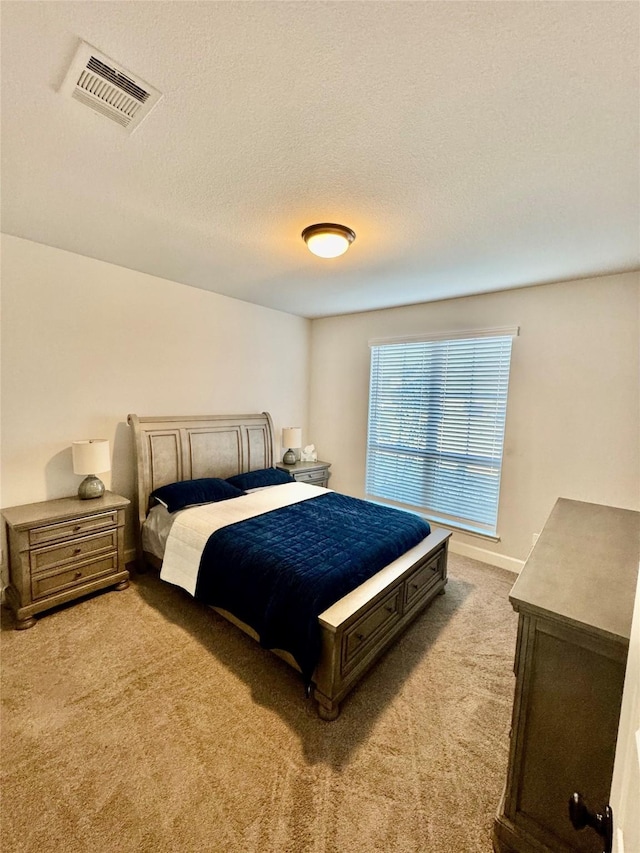 bedroom with a textured ceiling and carpet flooring