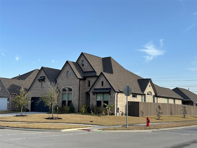 view of front of house featuring driveway, a garage, a shingled roof, fence, and brick siding