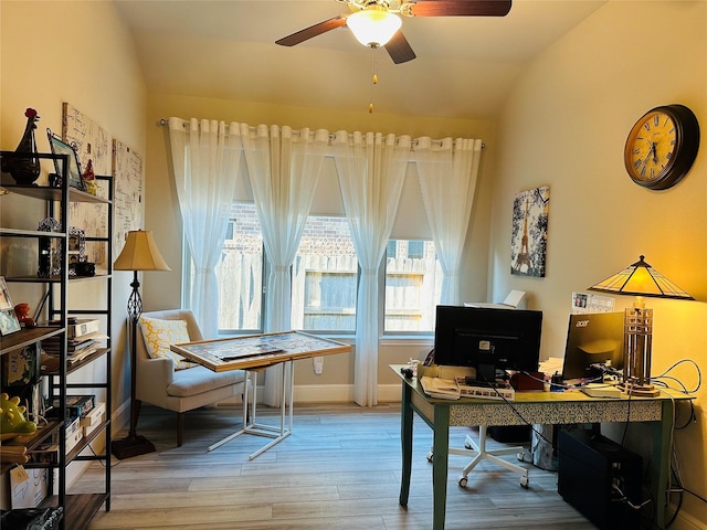 office space featuring lofted ceiling, baseboards, a ceiling fan, and wood finished floors