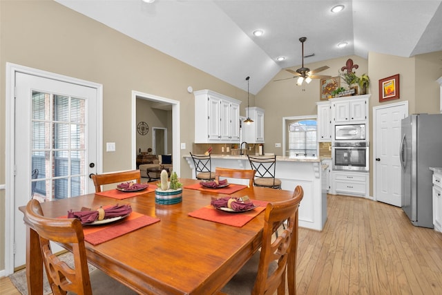 dining space with high vaulted ceiling, light hardwood / wood-style floors, and ceiling fan