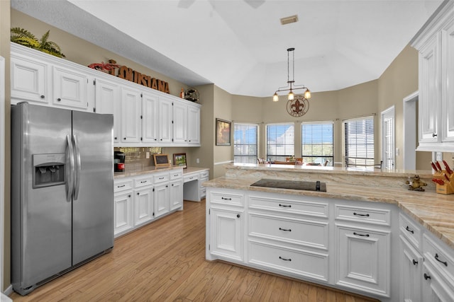 kitchen with hanging light fixtures, stainless steel fridge, black electric stovetop, light hardwood / wood-style floors, and white cabinets