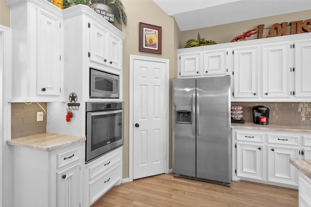 kitchen with tasteful backsplash, stainless steel appliances, light hardwood / wood-style floors, and white cabinets