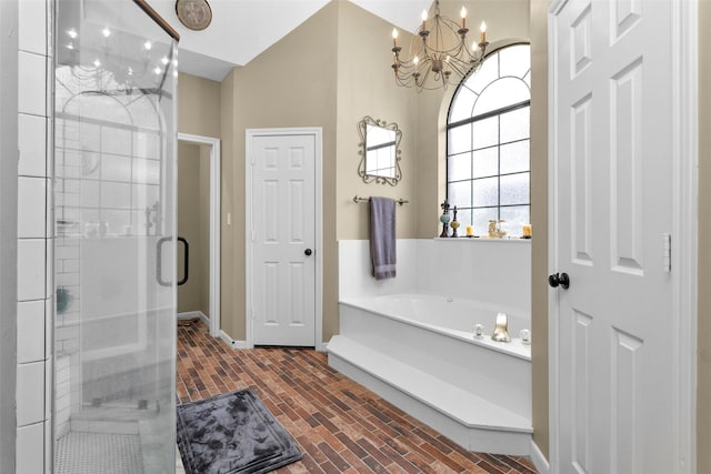 bathroom with independent shower and bath and a chandelier