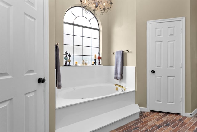 bathroom featuring a tub to relax in and a notable chandelier