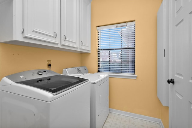 clothes washing area with cabinets and independent washer and dryer