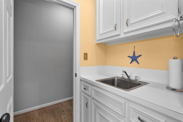 kitchen with white cabinetry, light hardwood / wood-style floors, and sink