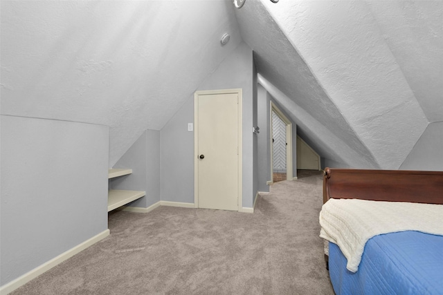 bedroom with light carpet, lofted ceiling, and a textured ceiling