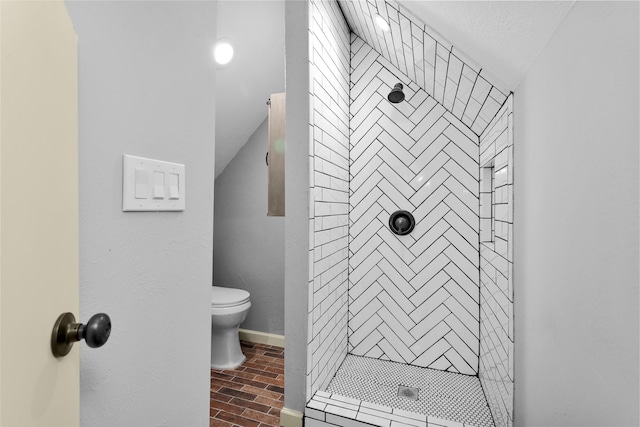 bathroom with toilet and a tile shower