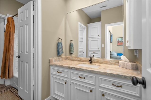 bathroom featuring vanity and shower / bathtub combination with curtain