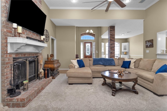 living room featuring ornate columns, crown molding, a brick fireplace, and ceiling fan with notable chandelier