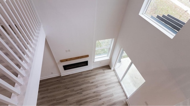 unfurnished living room featuring hardwood / wood-style floors and a towering ceiling