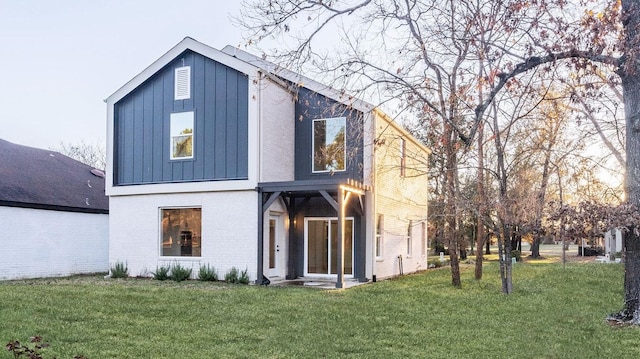 rear view of property featuring a lawn