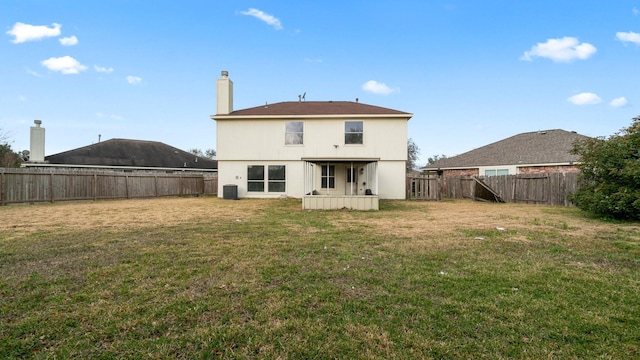 rear view of house with a lawn and cooling unit