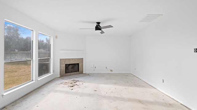 unfurnished living room with ceiling fan and a tile fireplace