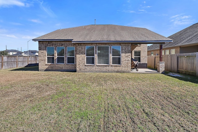 back of house featuring a patio area and a lawn