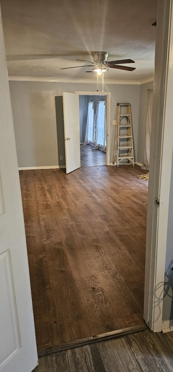 unfurnished room featuring ceiling fan, dark wood-type flooring, and a textured ceiling