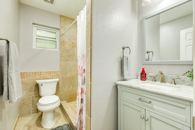 bathroom with toilet, tile walls, vanity, and curtained shower