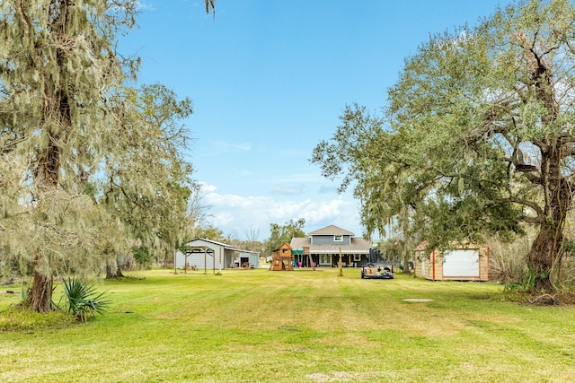 view of yard with a playground, a carport, and a storage unit