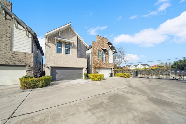 view of front of property with a garage, concrete driveway, brick siding, and fence