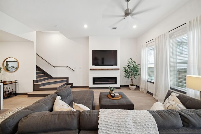 living room featuring light hardwood / wood-style floors and ceiling fan