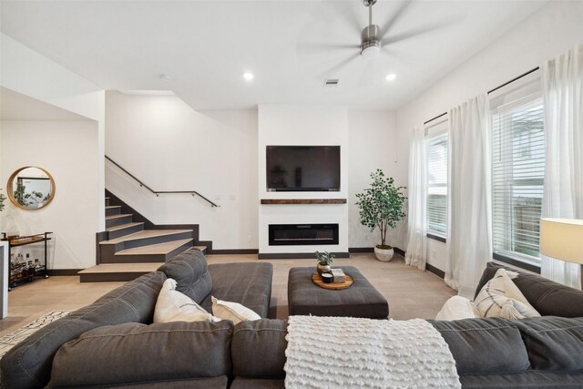 living room featuring ceiling fan, stairs, wood finished floors, baseboards, and recessed lighting