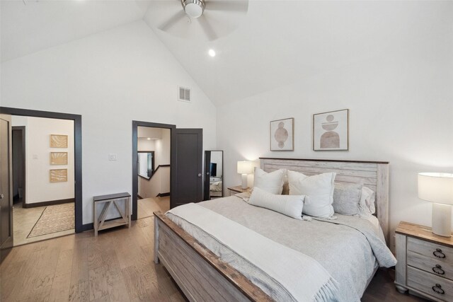 bedroom with high vaulted ceiling, ceiling fan, wood finished floors, and visible vents