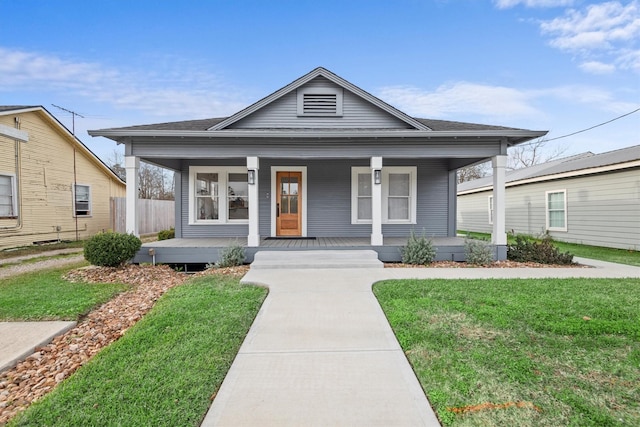 bungalow-style home with covered porch and a front yard