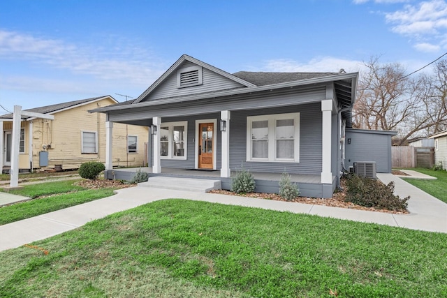 view of front of home featuring central air condition unit, covered porch, and a front yard