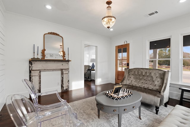 living room featuring dark hardwood / wood-style floors, ornamental molding, and a notable chandelier