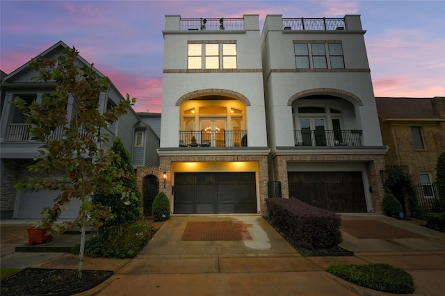 view of front of home featuring a garage, a balcony, and french doors