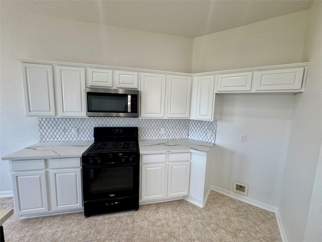 kitchen featuring light stone countertops, white cabinets, and black range with gas stovetop