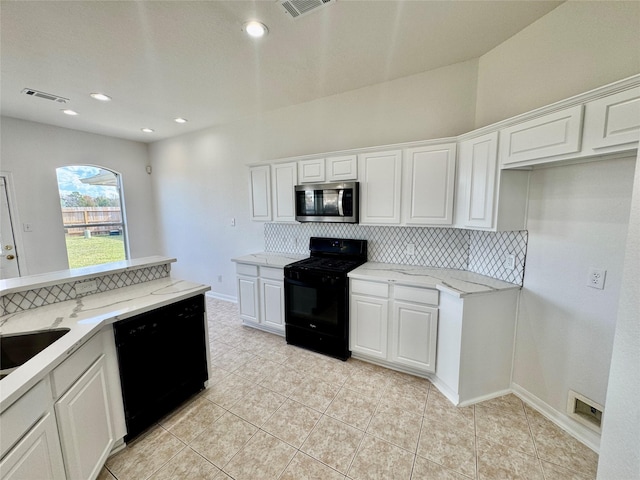 kitchen with tasteful backsplash, black appliances, light tile patterned flooring, white cabinetry, and light stone countertops