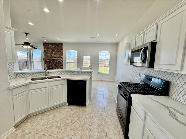 kitchen with white cabinetry, sink, kitchen peninsula, and black appliances