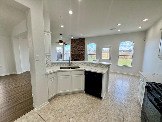 kitchen with black appliances, white cabinets, sink, and light tile patterned flooring