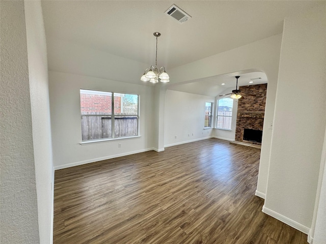 unfurnished living room with lofted ceiling, a fireplace, dark hardwood / wood-style flooring, and ceiling fan with notable chandelier