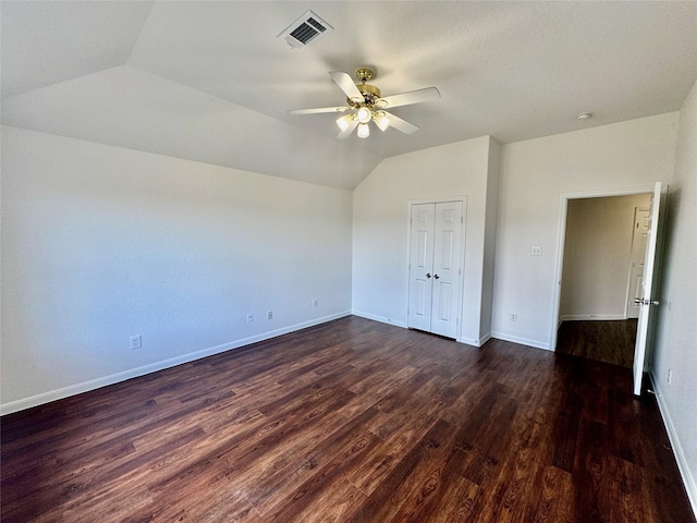 unfurnished bedroom featuring ceiling fan, dark hardwood / wood-style flooring, a closet, and vaulted ceiling