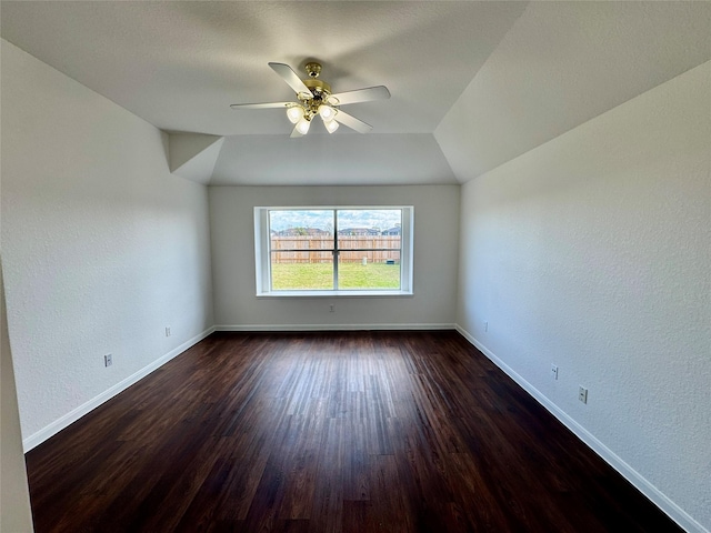 unfurnished room with ceiling fan, dark hardwood / wood-style floors, and vaulted ceiling