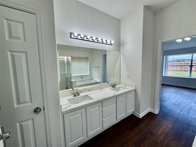 bathroom featuring a bath, hardwood / wood-style floors, and vanity