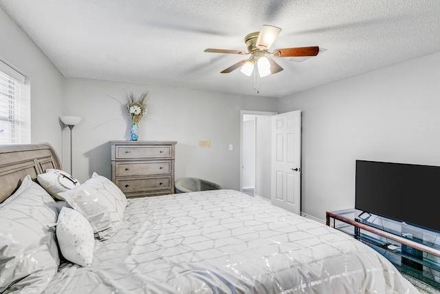 bedroom with ceiling fan and a textured ceiling